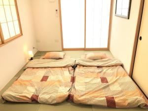 two beds in a room with two windows at 5-9-6 / Vacation STAY 59601 in Nago +12 photos