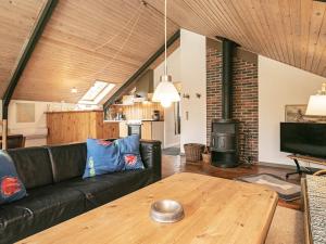 Nordskovにある5 person holiday home in Martofte-By Traumのリビングルーム(黒いソファ、木製テーブル付)