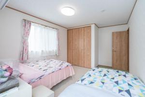 ein Schlafzimmer mit zwei Betten und einem Fenster in der Unterkunft Travel Palace Miyuki (Yomiuri Shimbun) / Vacation STAY 5715 in Kawaguchi