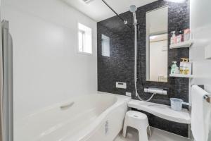 ein weißes Badezimmer mit Badewanne und Waschbecken in der Unterkunft Travel Palace Miyuki (Yomiuri Shimbun) / Vacation STAY 5715 in Kawaguchi + 26 Fotos