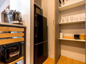 eine kleine Küche mit Kühlschrank und Regalen in der Unterkunft Rakuten STAY MOTEL Kujukurihama Katakai 203 1LDK with BBQ terrace in Kujukuri