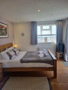 a bedroom with a large bed with blue curtains at Sandy Paws in Portreath