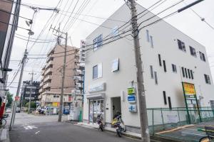 a scooter parked in front of a white building at Travel Palace Miyuki (Yomiuri Shimbun) / Vacation STAY 5734 in Kawaguchi