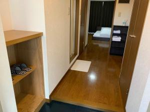 a room with a hallway with a bed and a wooden floor at AO Dazaifu / Vacation STAY 61719 in Chikushino
