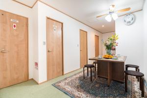 a room with a table and two chairs and a clock at Travel Palace Miyuki (Yomiuri Shimbun) / Vacation STAY 5735 in Kawaguchi
