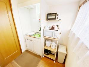 a small kitchen with a sink and a microwave at Petit Hotel 017 - Vacation STAY 60648v in Tokushima