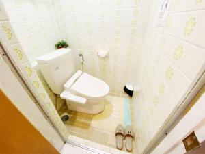 a small bathroom with a toilet and a pair of slippers at Petit Hotel 017 - Vacation STAY 60648v in Tokushima
