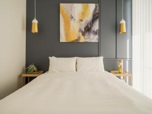a bedroom with a large white bed and two pendant lights at Naha - House / Vacation STAY 60932 in Naha