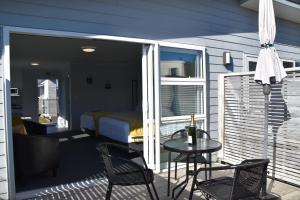 a balcony with a bed and a table and chairs at Trailblazer Studios in Waihi