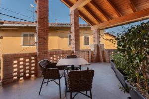 a table and chairs on a patio with a wooden roof at Decanter House in Borgomanero