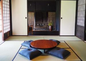 a room with a table and some blue cushions at Setouchi Cominca Stays Hiroshima Chojaya / Vacation STAY 64495 in Shōbara +1 photo