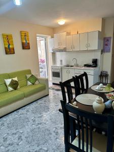 sala de estar con sofá verde, mesa y sillas en Sunny Balcony Retreat Pogradec, en Pogradec