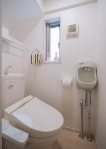 a white bathroom with a toilet and a sink at Comfort Miyako Building No.1 / Vacation STAY 68062 in Jima +33 photos