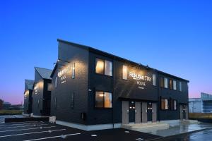 a black building in a parking lot at night at Rakuten STAY HOUSE Kisarazu in Kisarazu