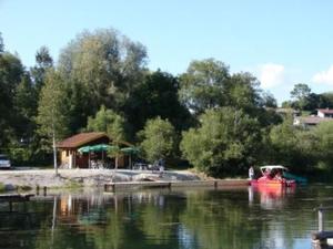 a boat in a body of water next to at Abendsonne in Lechbruck