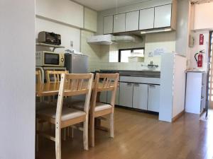 a kitchen with a table and chairs and a refrigerator at Weekly Harbourview Mansion Main Building / Vacation STAY 74570 in Naha