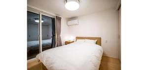a bedroom with a large white bed and a window at Rakuten STAY HOUSE x WILL STYLE Fujinomiya 101 in Fujinomiya