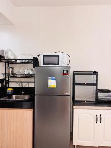 a kitchen with a stainless steel refrigerator and a microwave at Stylish and Trendy - Comfy Room With a Pool View in Iloilo City
