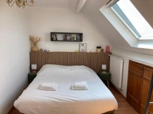 a bedroom with a bed with two towels on it at Les portes du golf Wimereux - Face mer in Wimereux