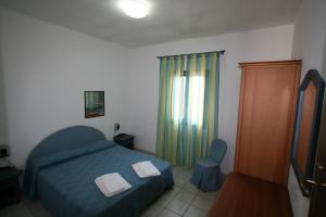 a bedroom with a blue bed with two towels on it at Residence Club Barbara in Ostuni