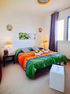 a bedroom with a bed with a colorful comforter at Guest House Safigumoru 5 minuti in spiaggia in Bari Sardo