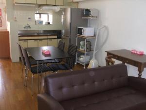 a living room with a couch and a table and a kitchen at Weekly Harbourview Mansion Main Building / Vacation STAY 74562 in Naha