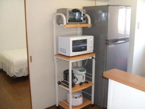 a kitchen with a microwave and a refrigerator at Weekly Harbourview Mansion Main Building / Vacation STAY 74567 in Naha