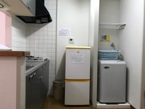 a small kitchen with a refrigerator and a sink at Weekly Harbourview Mansion Main Building / Vacation STAY 74722 in Naha +7 photos