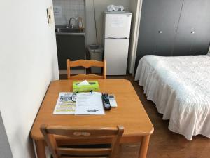 a room with a wooden table with a bed and a desk with a bedskirts at Weekly Harbourview Mansion Main Building / Vacation STAY 74728 in Naha