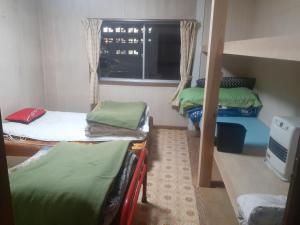 a room with three bunk beds and a window at Hamburger restaurant Big foot / Vacation STAY 6626 in Hachinohe