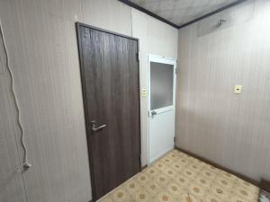 Una habitación vacía con una puerta y un pequeño armario. en Hamburger restaurant Big foot - Vacation STAY 16266, en Hachinohe