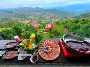 a table with plates of food and a grill on it at Leesuma Homestay in Ban San Pu Loei