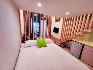 a bedroom with a large white bed with a green pillow at 湯韻溫泉 in Jiaoxi