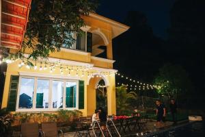 people sitting at a table outside of a house with lights at Truong Casa in Tam Ðảo +7 photos
