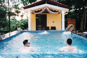 two men are swimming in a swimming pool at Truong Casa in Tam Ðảo