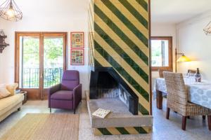 a living room with a fireplace and a dining room at Can Cardina - Casa con jardín cerca de Francia in Maçanet de Cabrenys