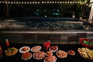 a table with plates of food on it with a pool at Truong Casa in Tam Ðảo