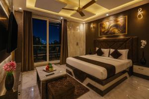 a bedroom with a large bed and a balcony at Hotel Downtown, Sector 51 in Noida