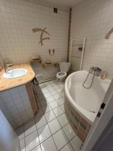 ein Badezimmer mit Badewanne, Toilette und Waschbecken in der Unterkunft Appartement Cosy avec Vue Montagne, Balcon & Parking Gratuit in Font Romeu Odeillo Via