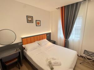 a bedroom with a bed and a desk and a mirror at Pepper Inn in Sibu