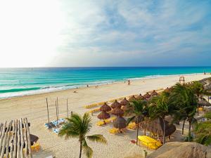 
a beach filled with lots of beach chairs and umbrellas at Iberostar Tucan in Playa del Carmen
