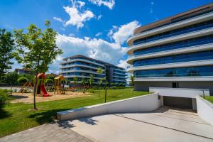 an apartment building with a playground and a park at MyFlat Wave Beach39 Apartment in Siófok