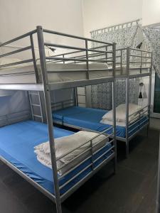 2 stapelbedden in een kamer met blauwe lakens bij Royal Lodge @ Pagoda Street in Singapore