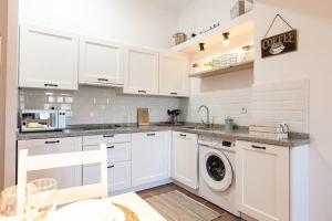 une cuisine avec des armoires blanches et une machine à laver dans l'établissement Moraima parking incluido, à Sierra Nevada