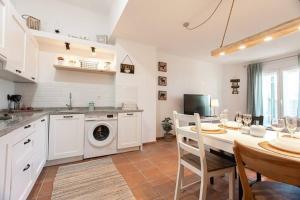 une cuisine avec une table et une machine à laver dans l'établissement Moraima parking incluido, à Sierra Nevada