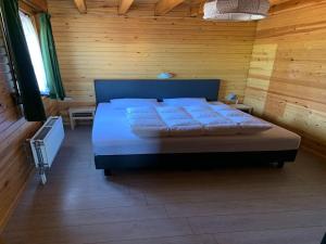 a bedroom with a bed in a wooden room at Peaceful Retreat with Sauna in Fraiture
