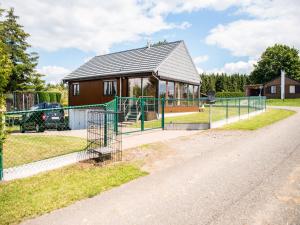 a house with a fence in front of it at Peaceful Retreat with Sauna in Fraiture