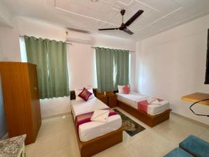 a room with two beds and a ceiling fan at Ved Bhoomi residency in Rishīkesh