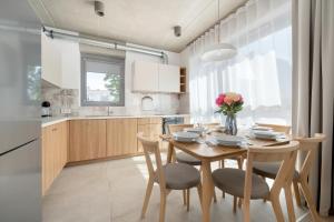 a kitchen and dining room with a wooden table and chairs at Luxury Apartments with Parking and Air Conditioning near Wrocław City Center by Renters Prestige in Wrocław