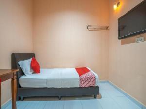a bedroom with a bed with a tv on the wall at Sz Hotel in Lumut
